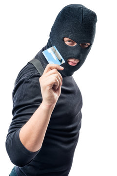 Hacker in black clothes with a bank card in hand on a white background
