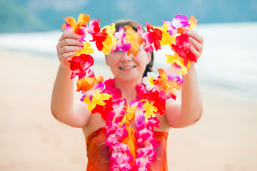 Girl on the beach welcomes guests with floral Lei traditional Hawaiian