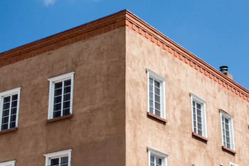 Fototapeta na wymiar Corner of an adobe building with white windows