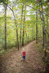 Girl walking down trail in the forest