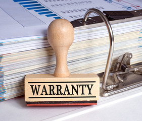 Warranty stamp with text on desk in the office with binder - certificate, guarantee, quality