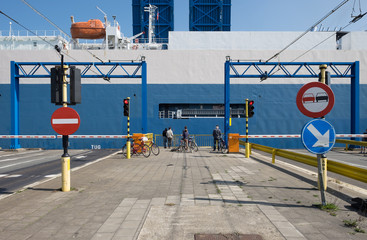 People watching a vessel sail by a lock in Zeebrugge, Belgium