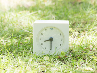 White simple clock on lawn yard, 8:30 eight thirty half