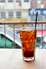 Glass of soft drink with ice on the table and contrasts of the foreground and out of focus the background