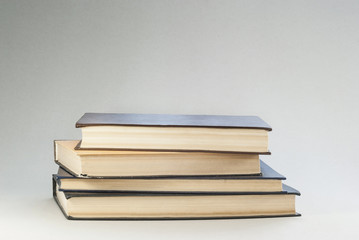 Old books with redened pages are stacked