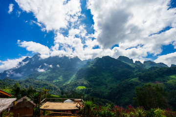 Fog and cloud over green mountains on blue sky background in thailand.