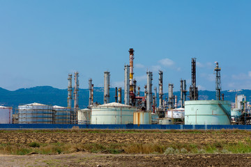 Fototapeta na wymiar Industrial refinery plant with mountain in the background