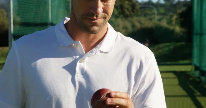 Confident cricket player holding ball during a practice session