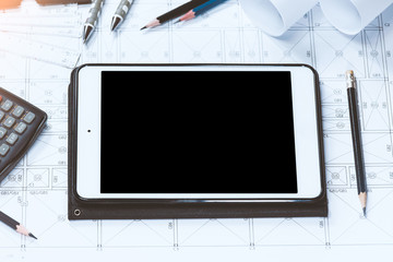 Digital tablet with drawings tools on abstract engineering drawings background.