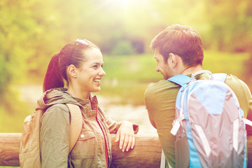 Fototapeta premium smiling couple with backpacks in nature