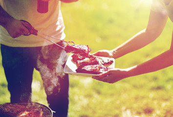 man cooking meat at summer party barbecue