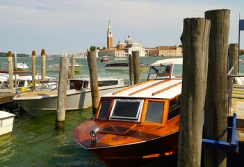 A nice wooden water taxi moored in the Grand canal in venice with San Giorgio Maggiore in the background