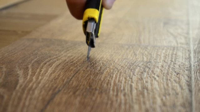 the worker cuts off the linoleum with a utility knife,fitting of linoleum floor.