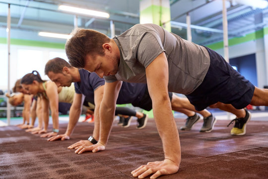 group of people doing straight arm plank in gym