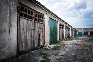 Fototapeta premium A dilapidated garage building against a cloudy evening sky