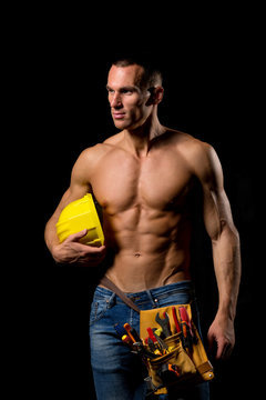 sexy fit shirtless worker with saw and tools
