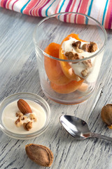 Apricot with cream and nuts in a glass