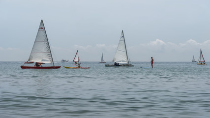 Fototapeta premium Rest on sea. Sea kayak, boats with sail, catamaran, stand up paddler. Outdoor sea sporting activity