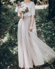 stylish wedding bride with bouquet and amazing modern dress. bride posing and smiling in sunny...