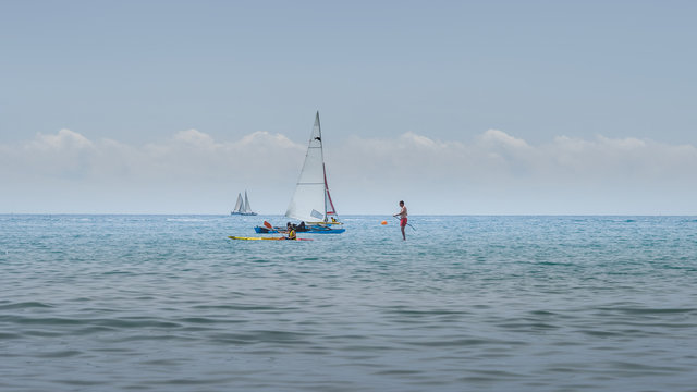 Rest on sea. Sea kayak, boats with sail, stand up paddler. Outdoor sea sporting activity