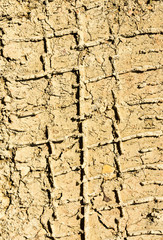 Traces of tires on clay dirt road close-up background texture