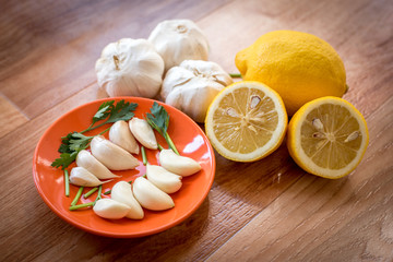Mix of vegetables garlic lemon and parsley on a table for preparing healthy diet receipt