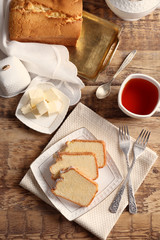 Plate with delicious sliced butter cake on wooden table