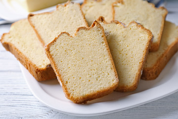 Plate with delicious sliced butter cake on wooden table