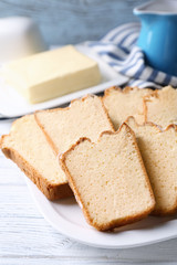Plate with delicious sliced butter cake on wooden table