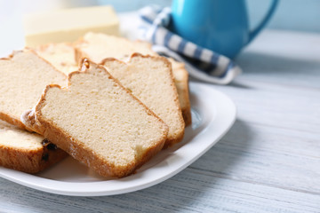 Plate with delicious sliced butter cake on wooden table