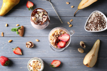 Delicious yogurt parfait and ingredients on table