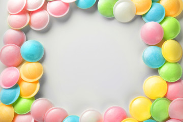 Frame made of tasty colorful candies on white background