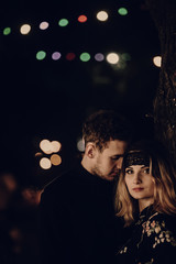 passionate lovers embracing in evening city street. stylish couple in love gently hugging in city lights. modern woman and man romantic french atmospheric moment.