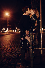 Sexy couple kissing outdoors in the street, two lovers kiss in night street in Paris on their...