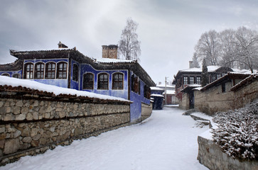 Beautiful  view with historic traditional houses in an old town in Europe with cloudy sky. Winter  time. It is snowing.  Koprivshtitca. Bulgaria.