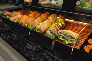 Fridge with bakery products in shop, closeup