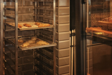 Rack with pastry on trays in bakery