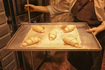Woman holding tray with pastry in bakery