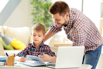 Father and son doing homework together at home