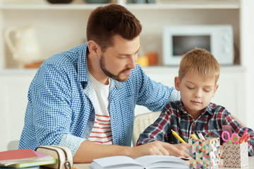 Father and son doing homework together at home