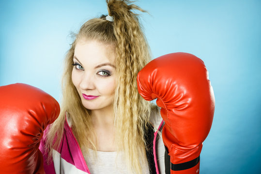 Funny girl in red gloves playing sports boxing