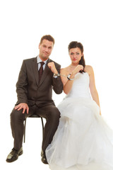 Bride and groom in handcuffs wearing wedding outfits