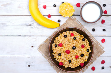 The concept of a healthy breakfast: muesli, banana and a glass of milk on a wooden table, free space.
