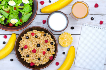 The concept of a healthy breakfast: muesli, banana and a glass of milk on a wooden table, free space.