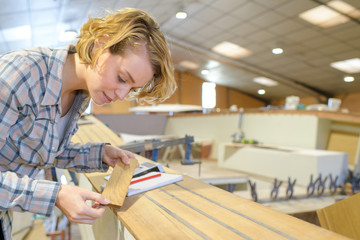 Woman matching wood sample to boat