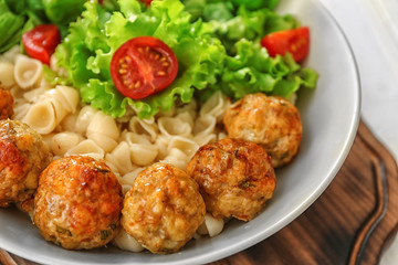 Plate with turkey meatballs and pasta on table, closeup