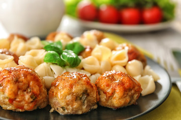 Plate with turkey meatballs and pasta on table, closeup