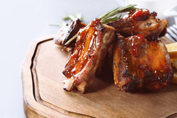 Delicious pork ribs with rosemary on wooden board, closeup