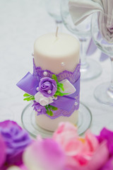 Wedding in lilac color. Decor of flowers and fabrics. Candle
