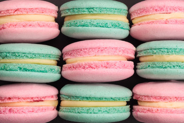 Top view of colorful macaroons on black background